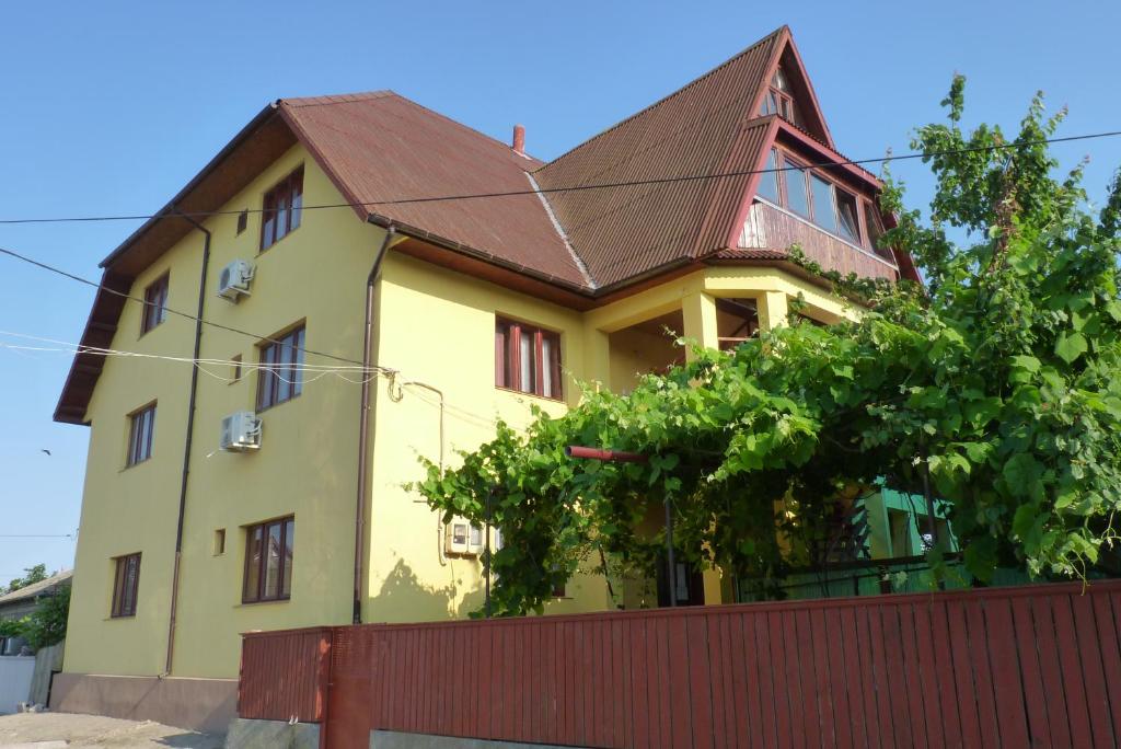 żółty dom z brązowym dachem w obiekcie Casa Maxim w mieście Sulina