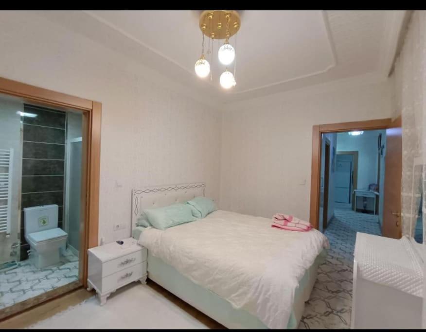 a bedroom with a bed and a bathroom at Merkezi konumda aile için uygun in Kilis