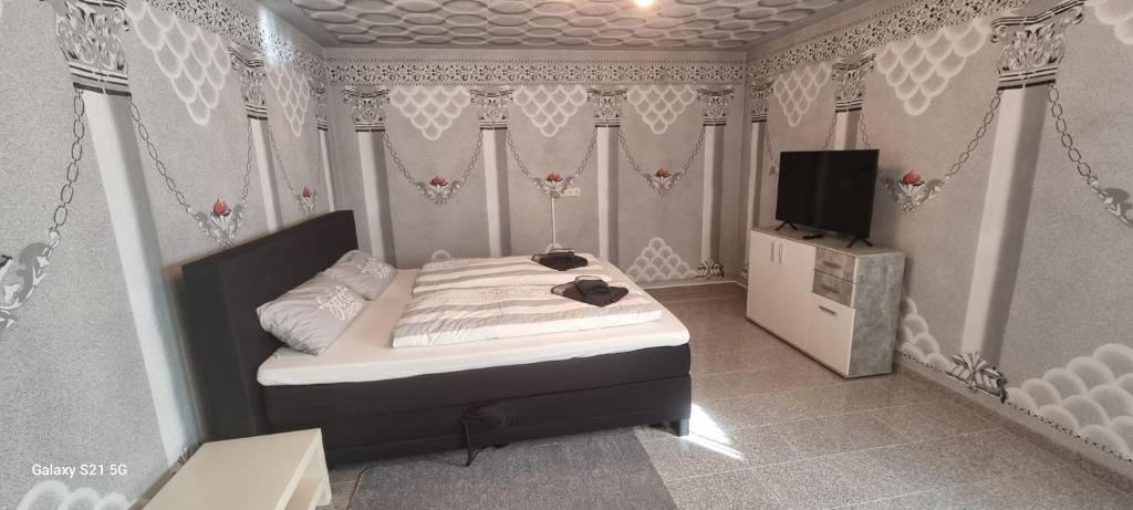 um pequeno quarto com uma cama e uma televisão em Ferienwohnung Elefanten em Balingen