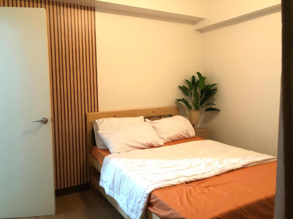 um quarto com uma cama e um vaso de plantas em Fia Horizons @ Infina South Tower em Manilla