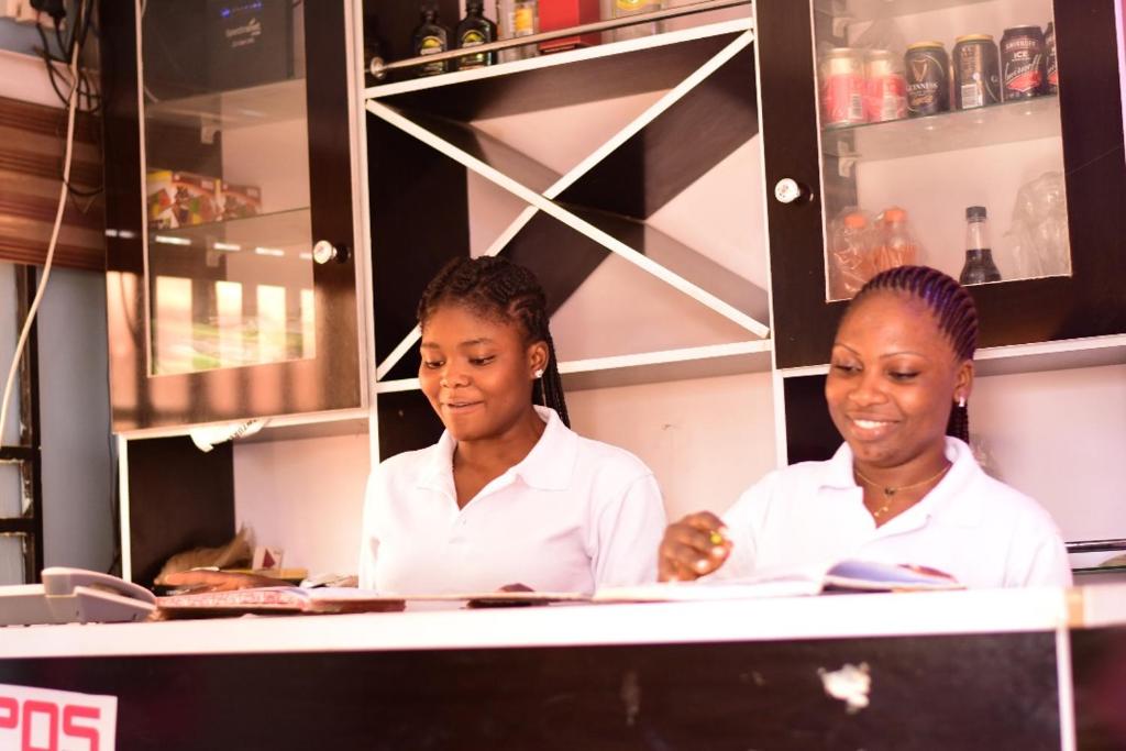 two women standing behind a counter in a kitchen at Royale Suites and Apartment in Abuja