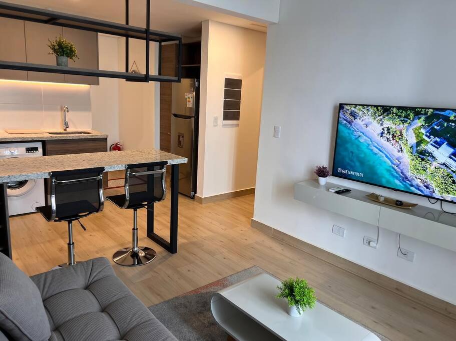 sala de estar con TV de pantalla plana grande en la pared en A estrenar! Departamento hermoso, en Asunción