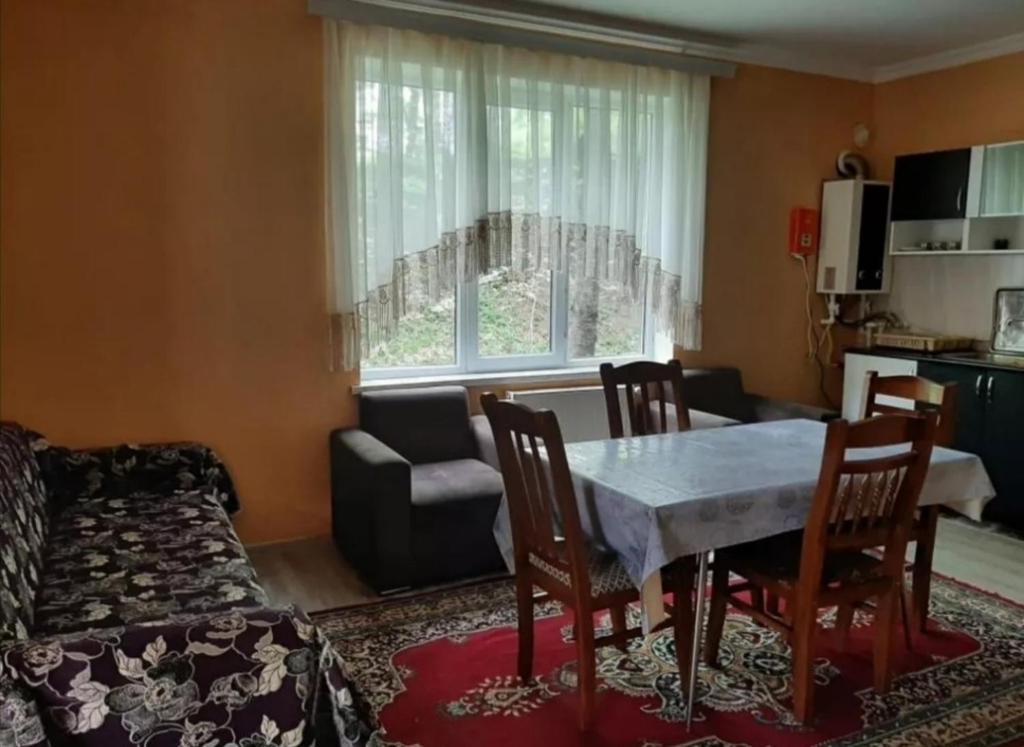 uma sala de estar com uma mesa e cadeiras e um sofá em Bağ evleri, villalar em Qǝçrǝş
