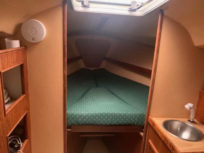 Habitación pequeña con lavabo y cama en el baño. en Sailboat Experience in Annapolis, en Annapolis