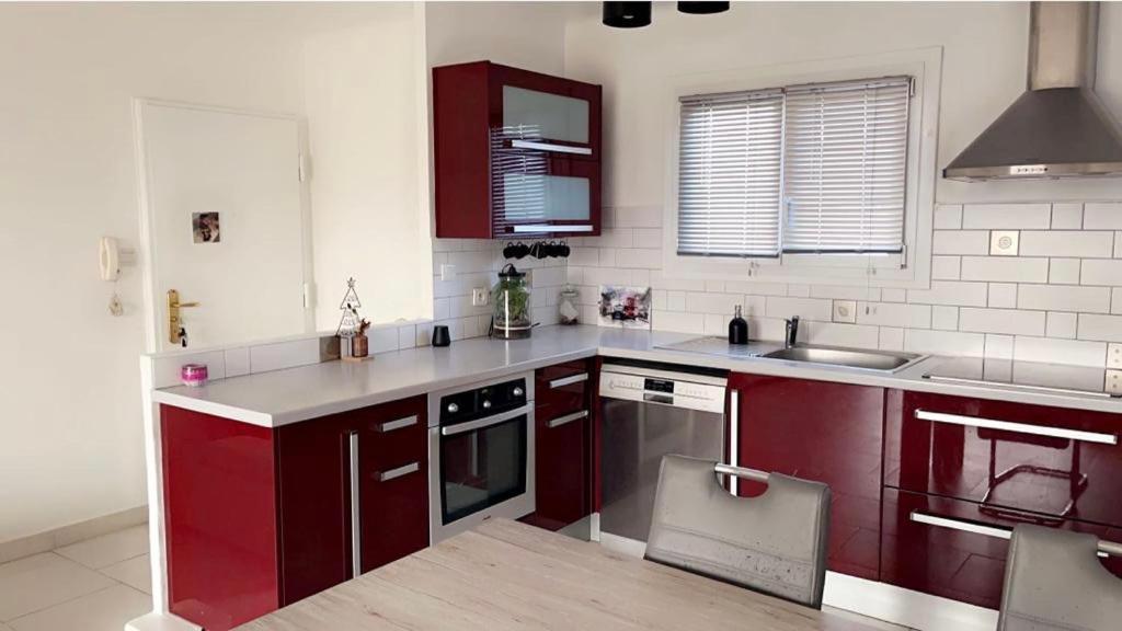 une cuisine avec des armoires rouges et un évier dans l'établissement House of Essia, à Aix-en-Provence