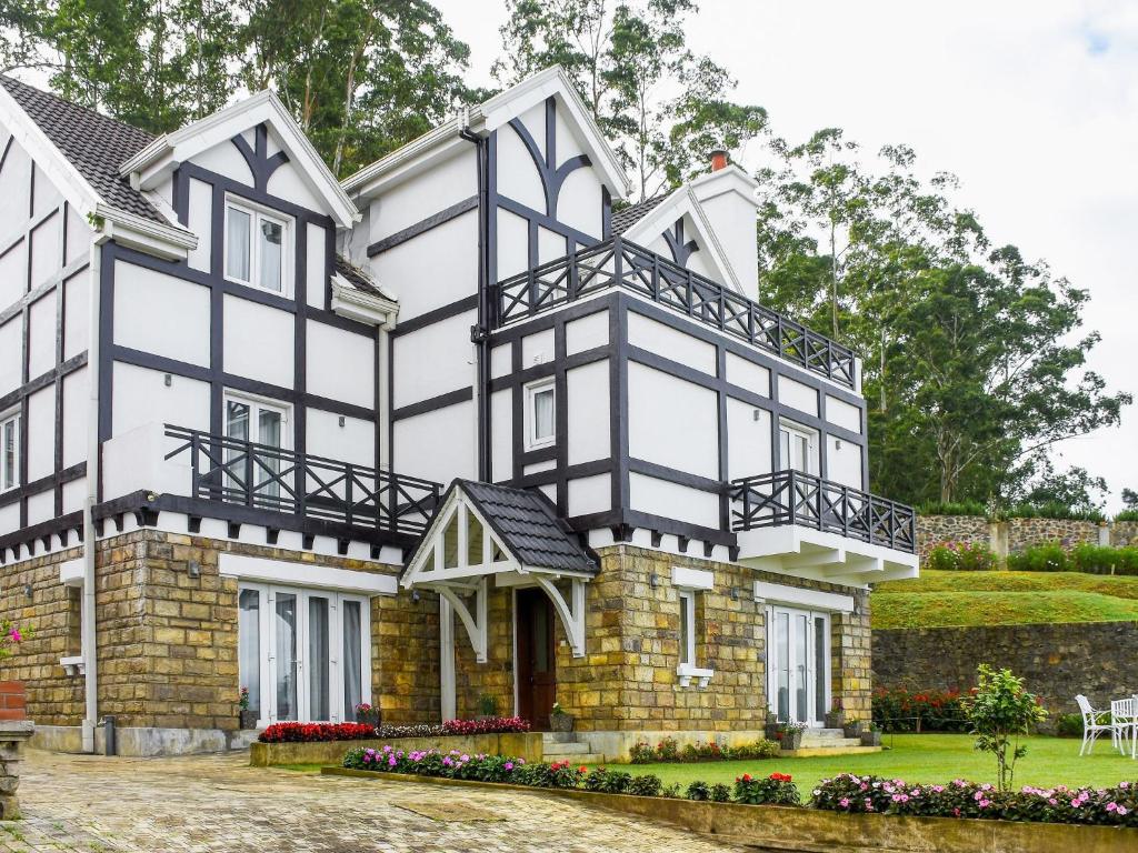 uma grande casa branca com acentos negros em Little England by Joes em Nuwara Eliya