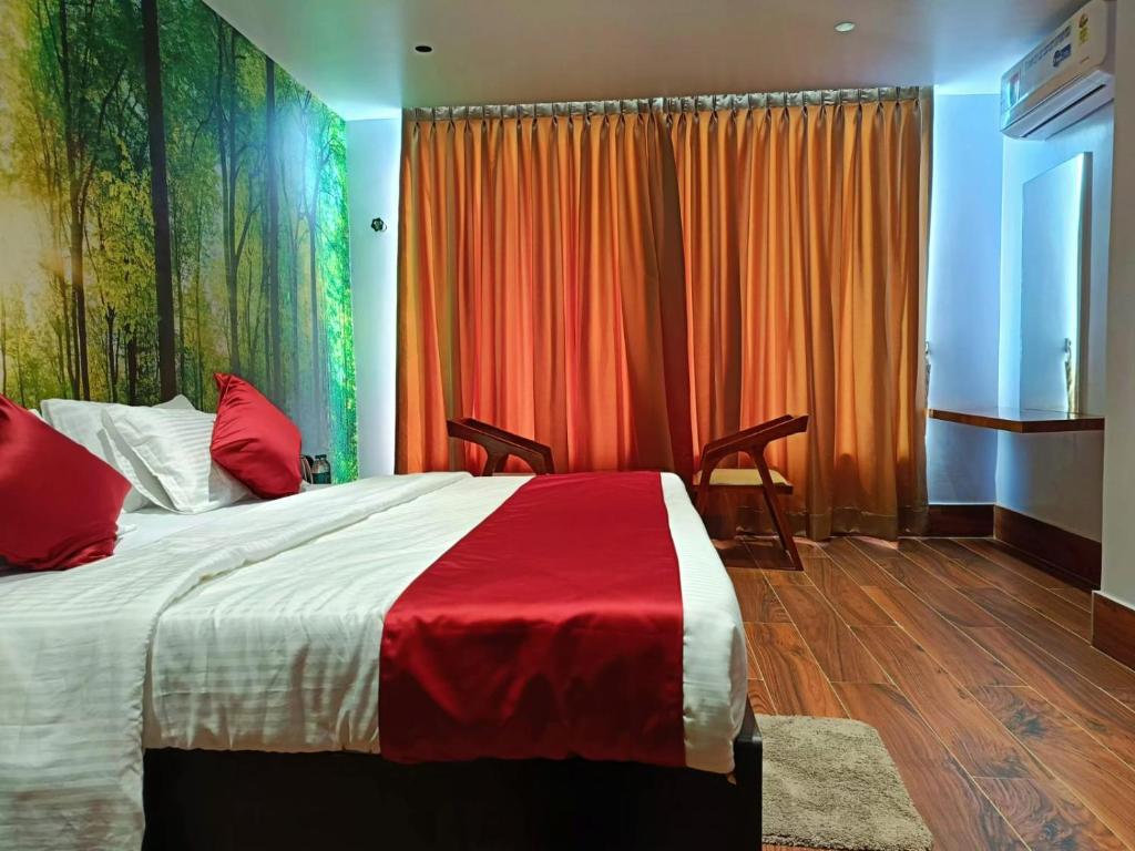 1 dormitorio con 1 cama con manta roja y blanca en Universal Hotel, en Bongaigaon