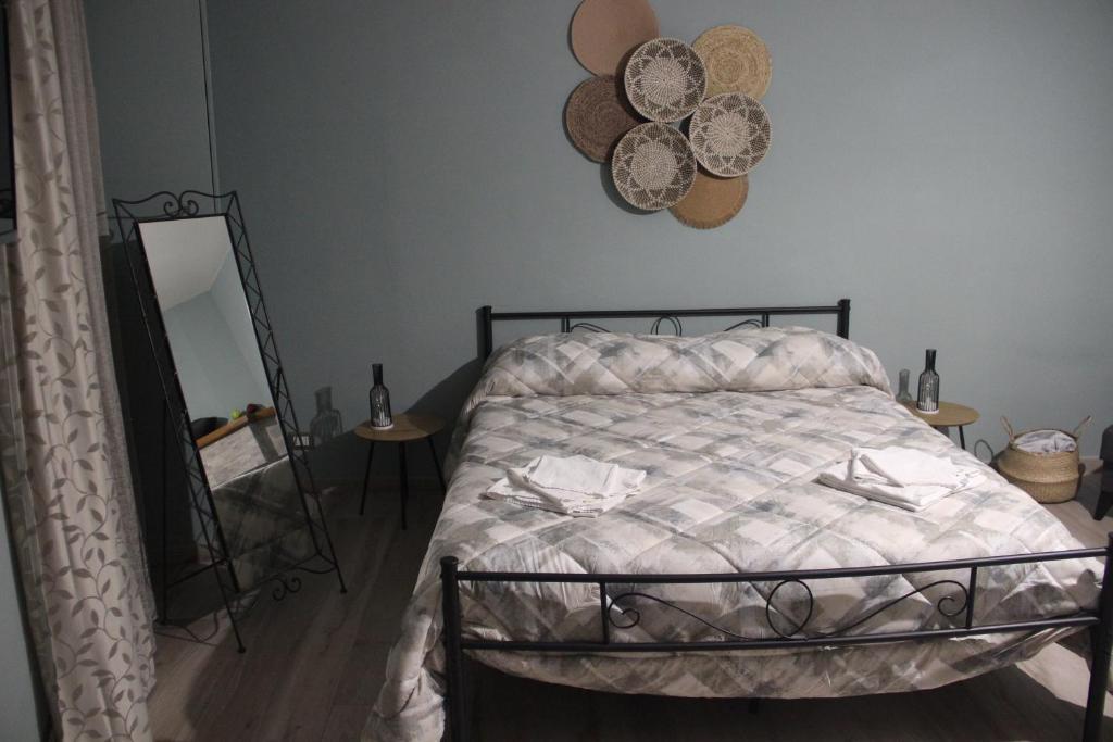1 dormitorio con cama y espejo en la pared en B&B Sud e Magia, en Castelmezzano