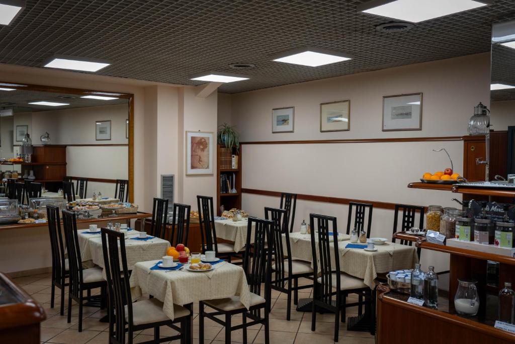 a dining room with tables and chairs and a whiteboard at Hotel Iris in Genoa