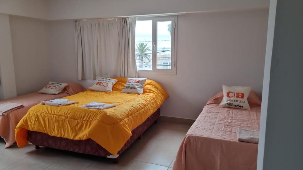 1 dormitorio con 2 camas y ventana en Hotel Costa Ballena en Puerto Madryn