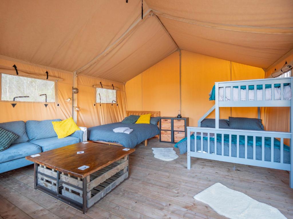 um quarto com um sofá e uma mesa numa tenda em Cobleland Campsite em Gartmore