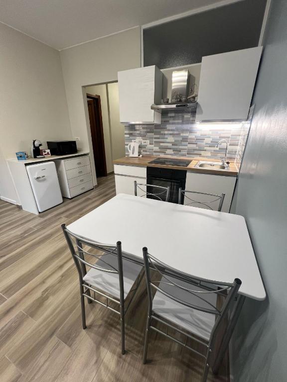 Hotel La Casa di Wendy, a kitchen with a white table and two chairs at La Casa di Wendy in Sanremo