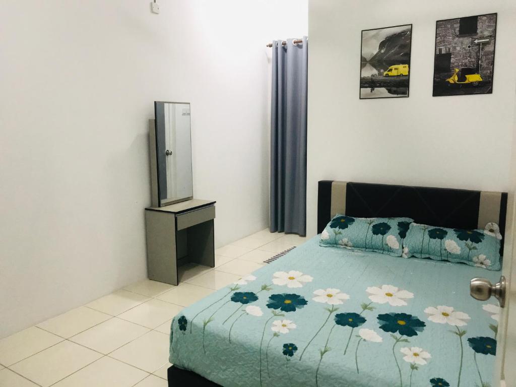 a bedroom with a bed with a blue comforter at Nur’s Homestay in Kuala Kelawang