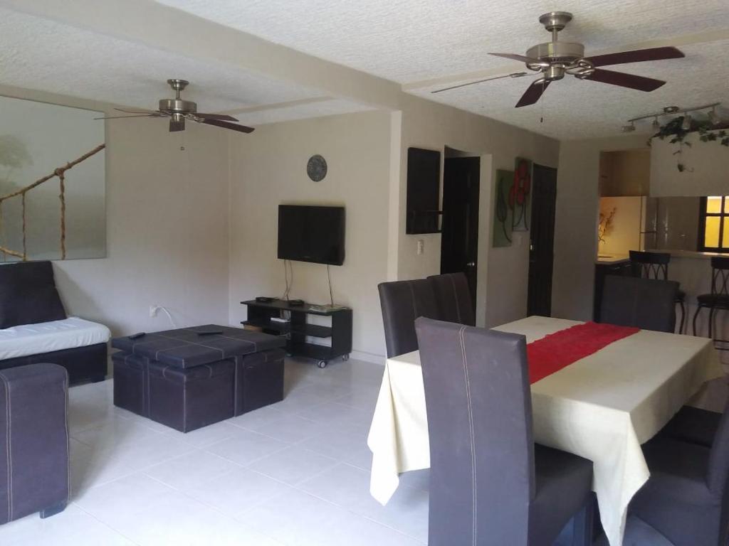 a living room with a bed and a tv at BEAUTIFUL HOME FULLY FURNISHED, READY TO RELAX AND 5 MINUTES FROM THE BEACH!! in Ixtapa