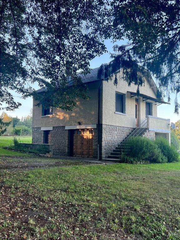 une grande maison en pierre avec une grande cour dans l'établissement Bruyères, Myrtilles et Monédières en Corrèze, 1, à Peyrissac