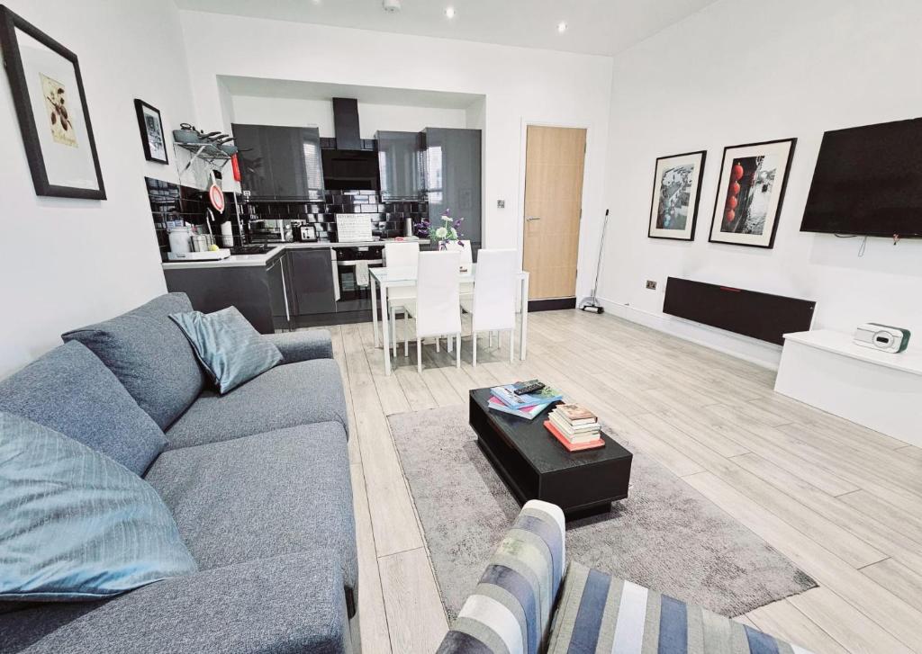 uma sala de estar com um sofá cinzento e uma cozinha em Stylish Apartment in Victorian Conversion FREE PARKING & PRIVATE PATIO Close to Beach Town Centre & BIC em Bournemouth