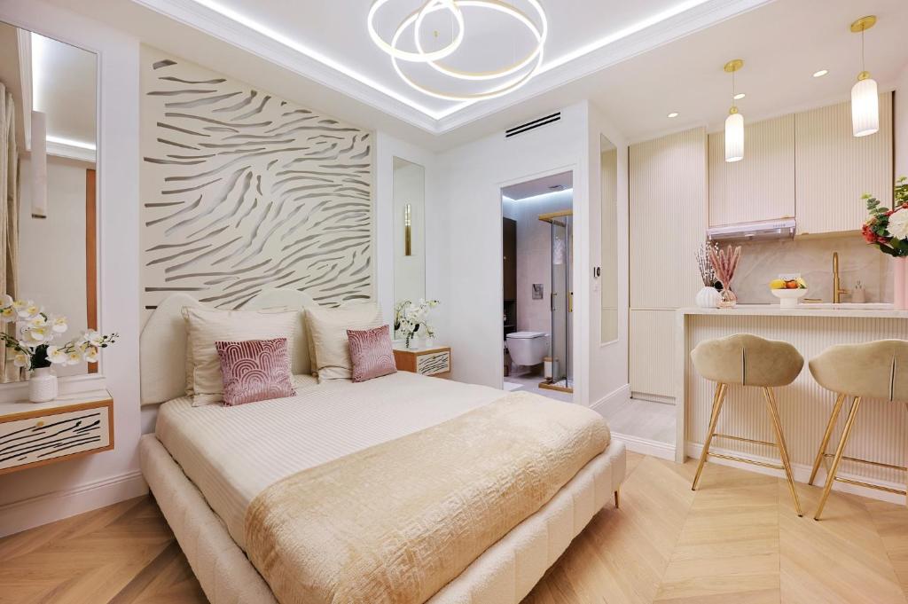 une chambre avec un grand lit et une cuisine dans l'établissement Bretagne Mairie du 3e, à Paris