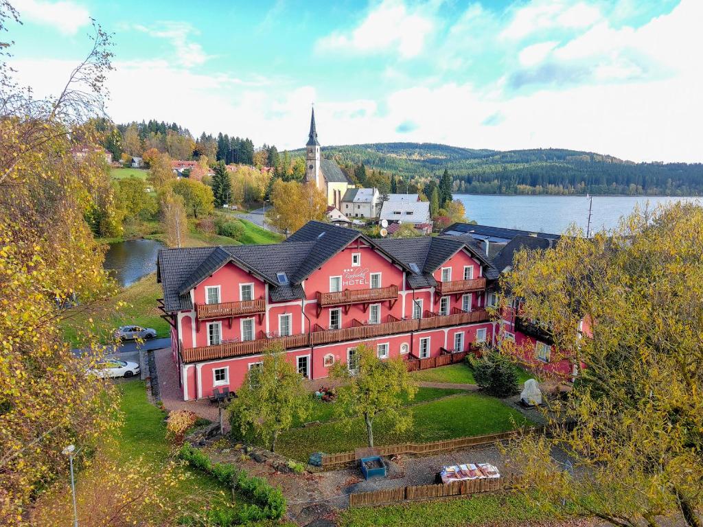 eine Luftansicht eines großen roten Hauses mit einer Kirche in der Unterkunft Hotel Barborka in Přední Výtoň