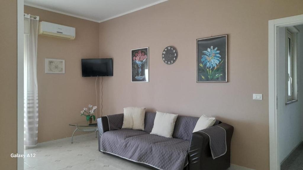ein Wohnzimmer mit einem Sofa und einem TV in der Unterkunft Villino Lufina in Carini