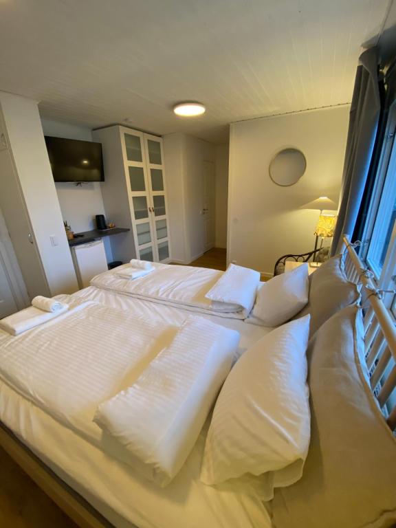 um quarto com 2 camas e almofadas brancas em SIGTUNA STUDIO em Sigtuna