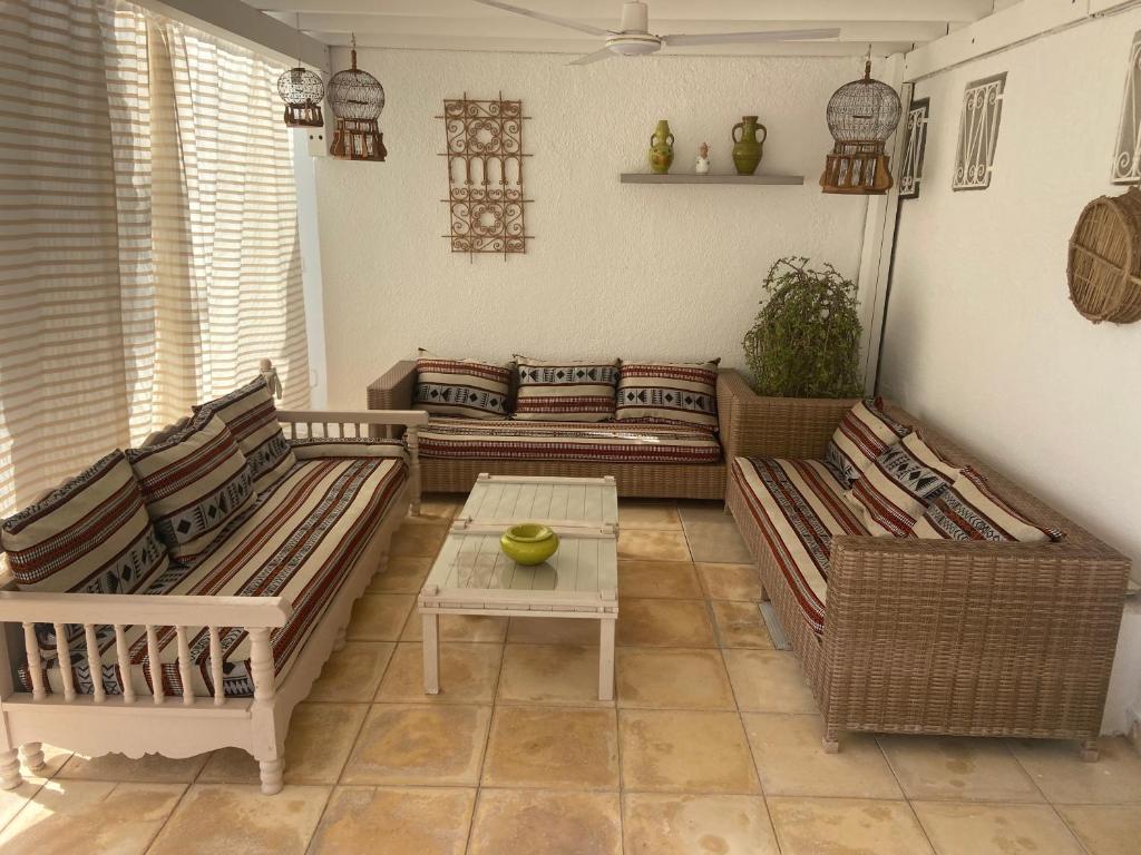 a living room with two couches and a table at RESIDENCE DAR YASMINa in Mezraya