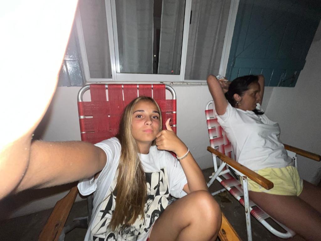 dos chicas sentadas en sillas en una habitación en Casa quinta Don bosco en Tandil
