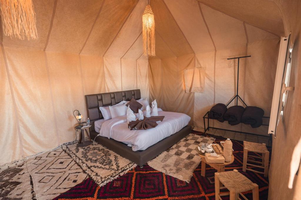 a bedroom with a bed in a tent at Enjoy Luxury Camp in Merzouga
