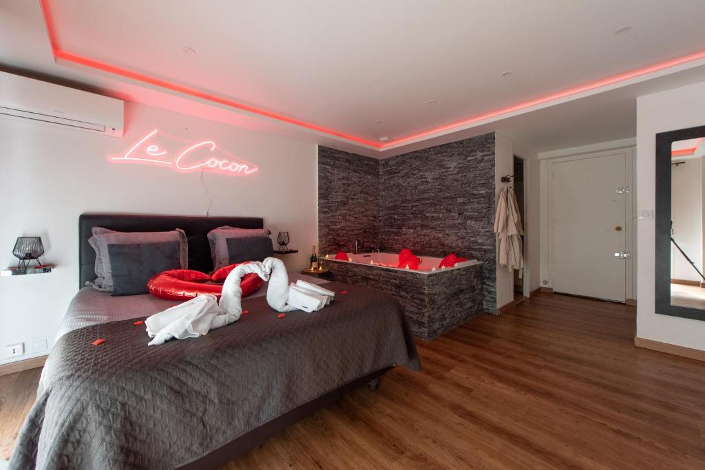 a bedroom with a bed with a neon sign on the wall at LE COCON- Jacuzzi & Sauna privés By SweetDreams in Le Cannet