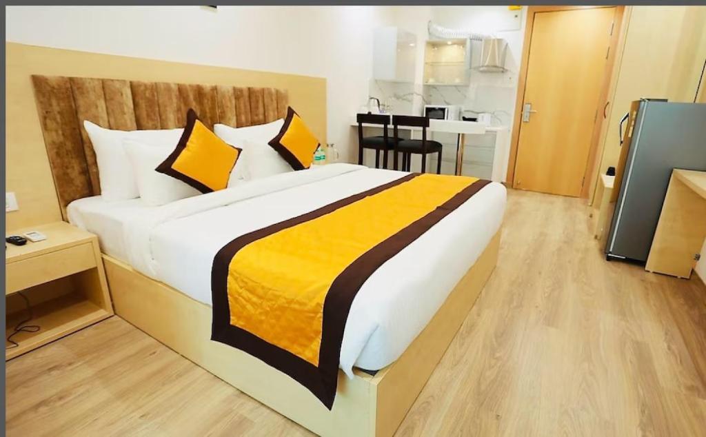 1 dormitorio con 1 cama grande con almohadas amarillas y negras en Diona Anukampa Suite with pool en Jaipur