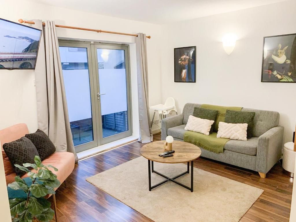 a living room with a couch and a table at Stunning 1 Bed flat in Canary Wharf FREE parking in London