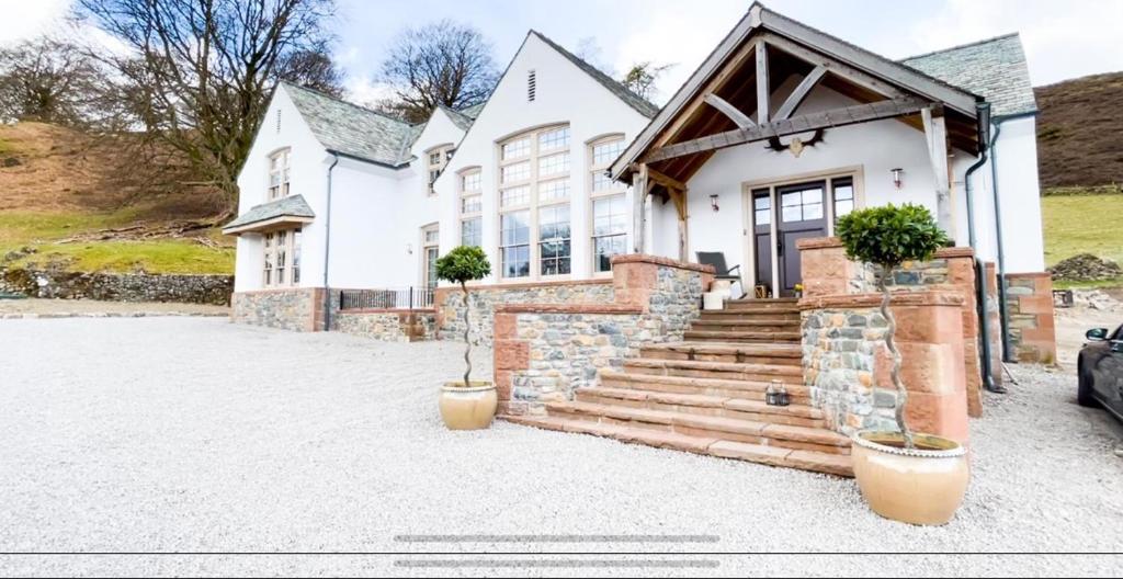 une maison blanche avec une allée en pierre dans l'établissement Luxury in the Lake District, à Dockray
