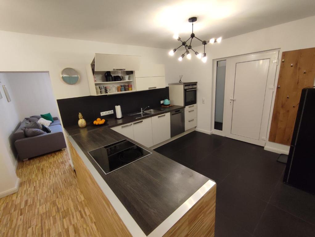 a kitchen with white cabinets and a black counter top at modernes Apartment in verkehrsgünstiger Lage in Flörsheim