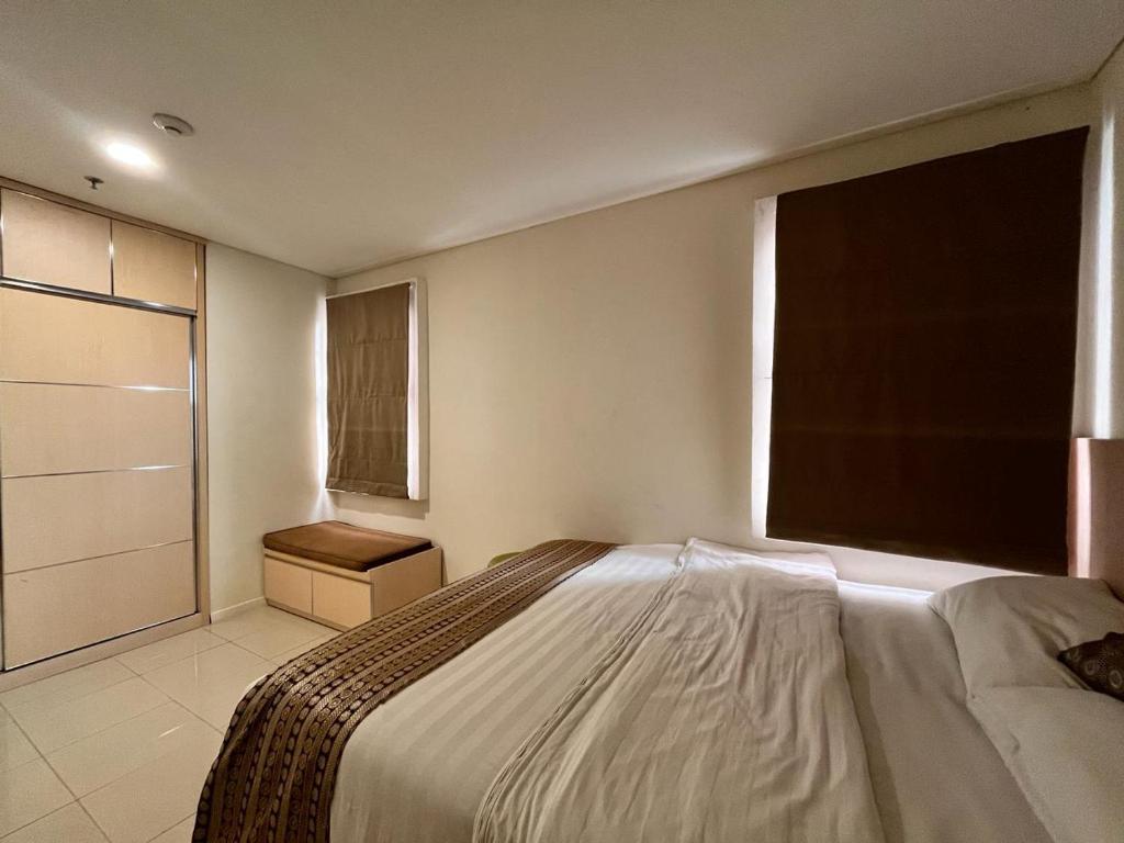 ein Schlafzimmer mit einem großen Bett und einem Fenster in der Unterkunft Comfy Rooms at Parahyangan in Bandung