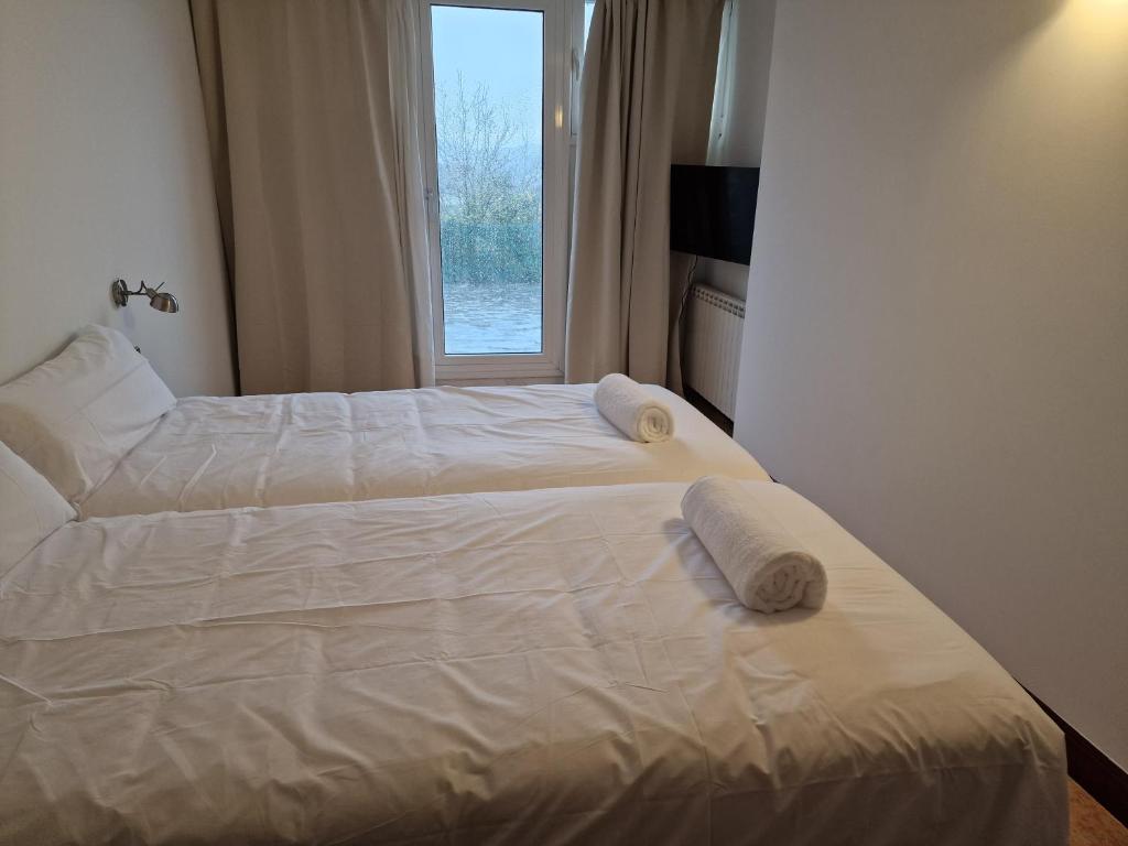 ein Schlafzimmer mit 2 Betten und Handtüchern darauf in der Unterkunft Pensión Aussie II in San Sebastián