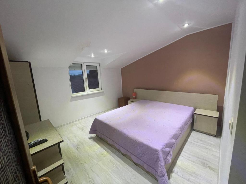 a bedroom with a bed with a purple blanket at Casa Croitoru in Mangalia