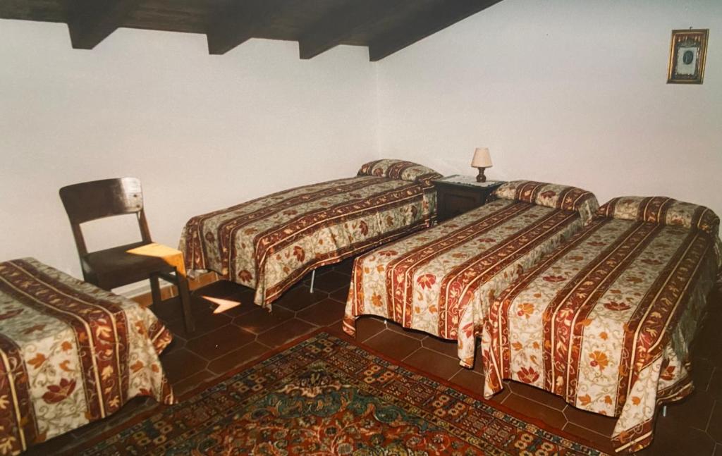 a hotel room with two beds and a chair at Casa di campagna in Marola