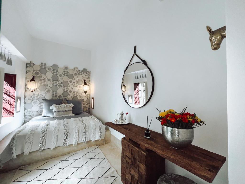 um quarto com uma cama e um espelho na parede em DAR AURORA em Marraquexe