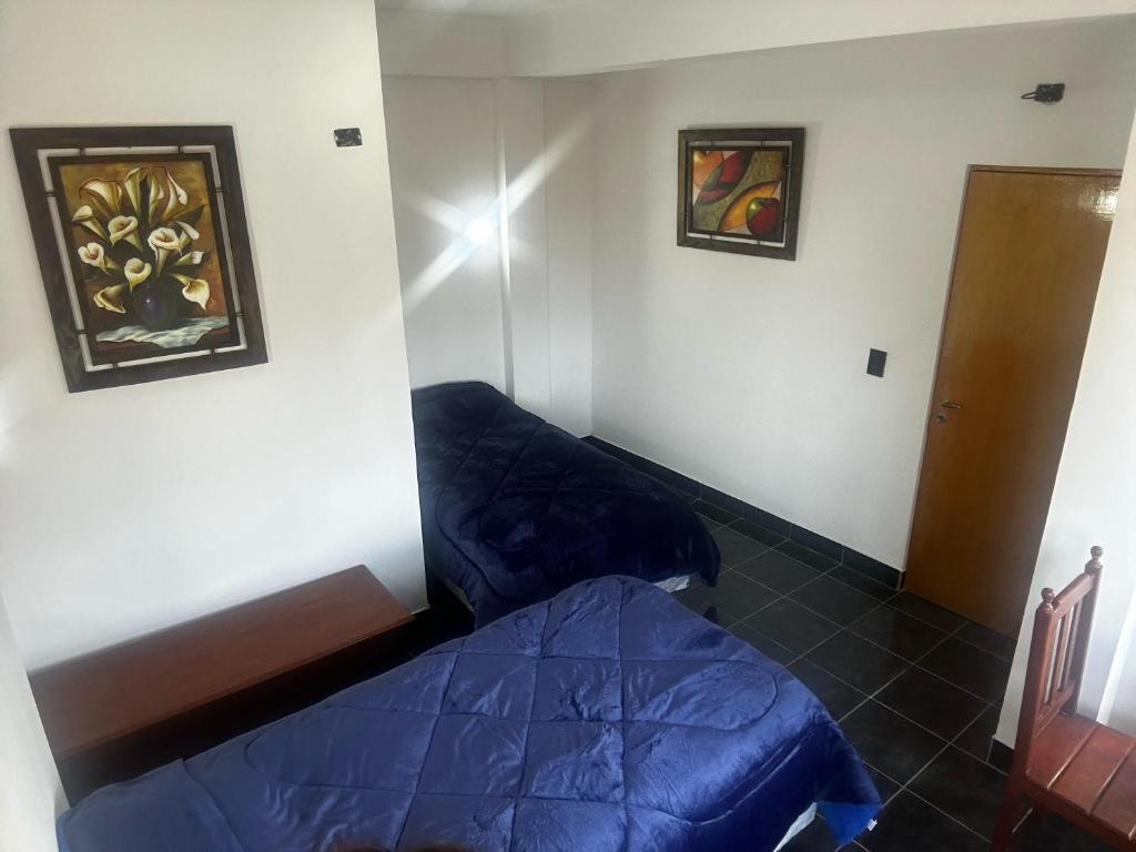Zimmer mit einem Bett und einem Wandgemälde in der Unterkunft Virginia hotel in La Quiaca