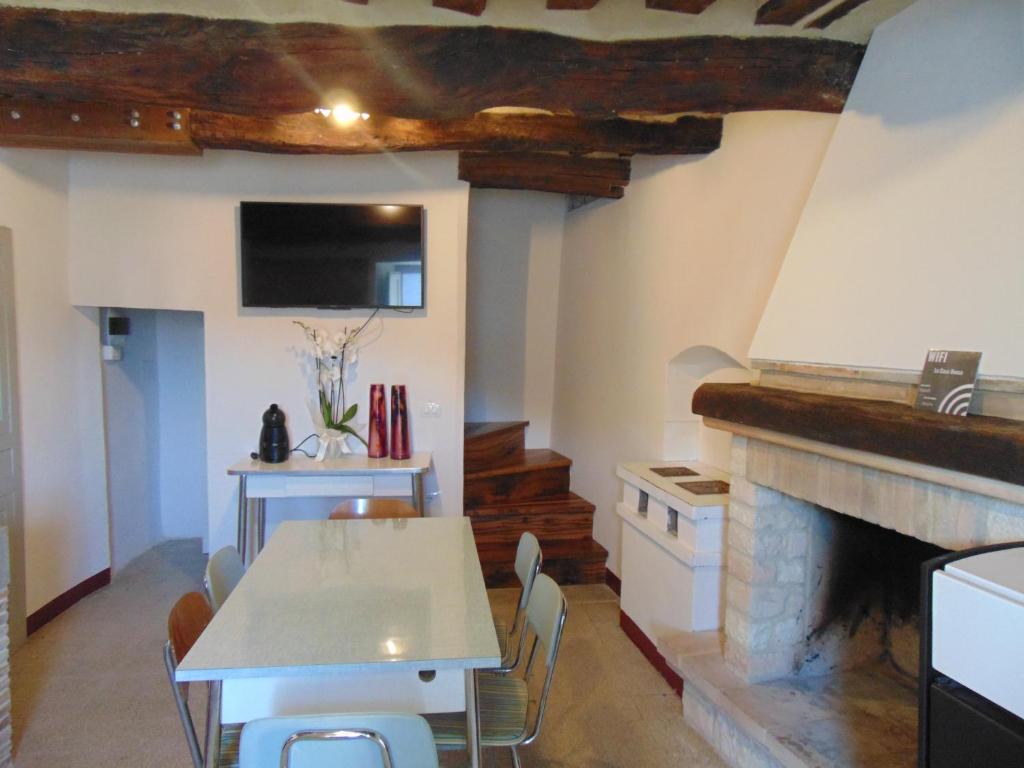 uma sala de jantar com uma mesa e uma lareira em SE051 - Palazzo d'Arcevia, accogliente trilocale ristrutturato em Cerrreto Grue