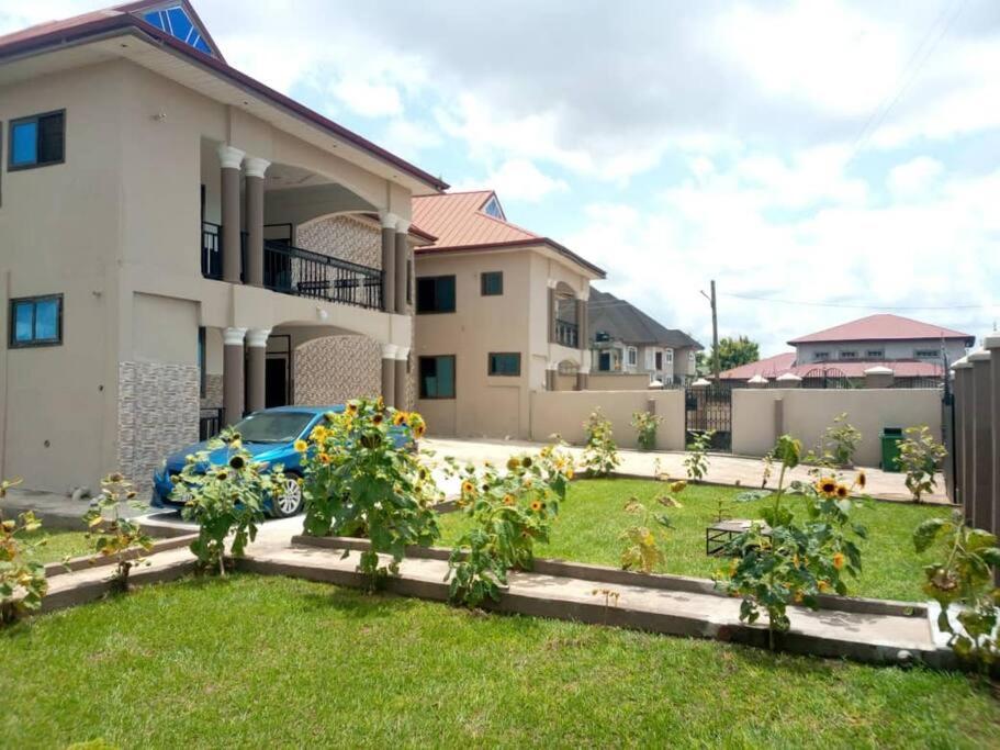 a house with a garden in front of it at Luxury Spacious Apartment in Kumasi