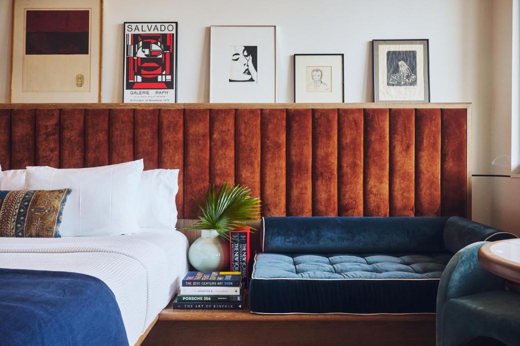 ein Schlafzimmer mit einem Bett mit einer blauen Bank daneben in der Unterkunft Hotel Henrietta in New Orleans