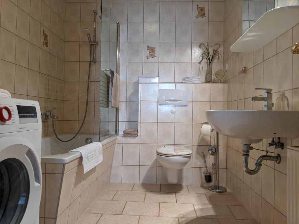 La salle de bains est pourvue d'un lavabo, de toilettes et d'une douche. dans l'établissement Ferienwohnung Am Ueckerpark, à Ueckermünde