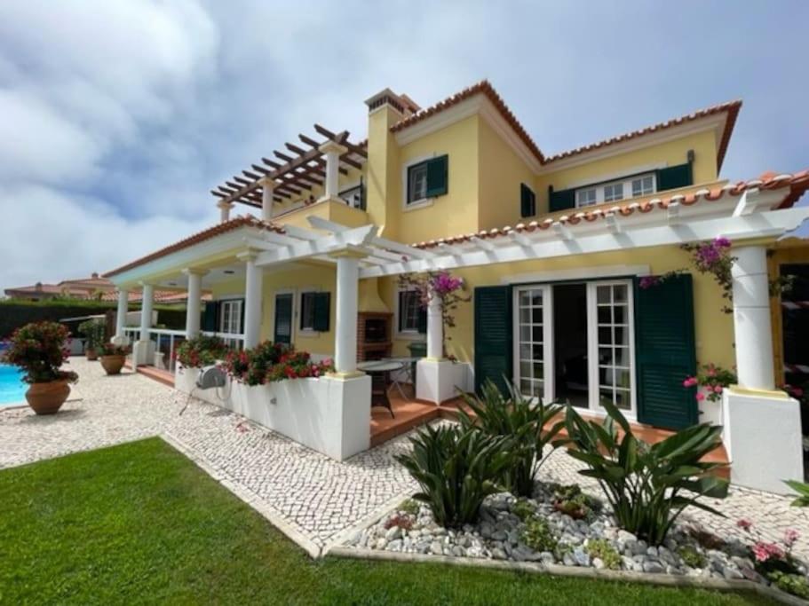 une maison avec une terrasse et une cour dans l'établissement Casa Da Luz Villa - Praia D'El Rey Golf Resort, à Casal da Lagoa Seca