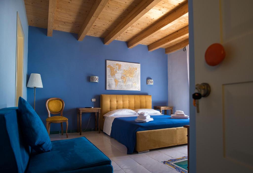 a blue bedroom with a bed and a chair at B&B Casa Martino SEA VIEW in Vietri