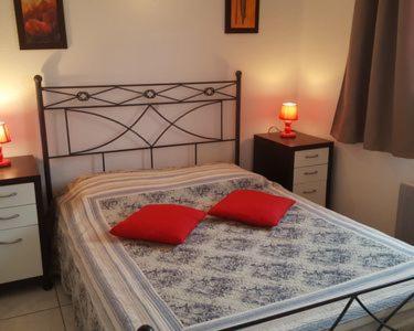 a bedroom with a bed with two red pillows at résidence lac de La Sole T3 4 pers les minimes avec piscine in La Rochelle