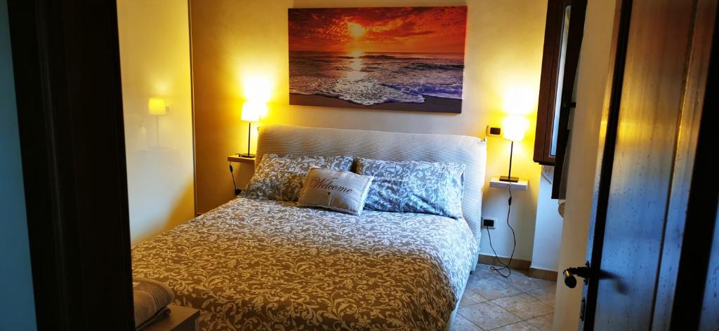 um quarto com uma cama com 2 candeeiros e um quadro em Dimora Charme em Monterotondo