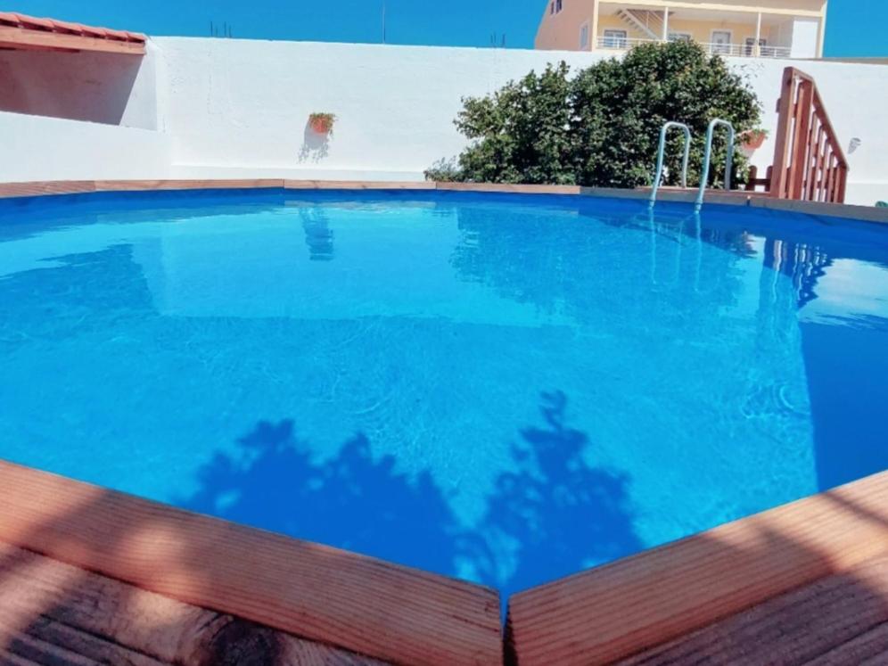 a large swimming pool with blue water at A Casa dos Azulejos in Santiago do Cacém