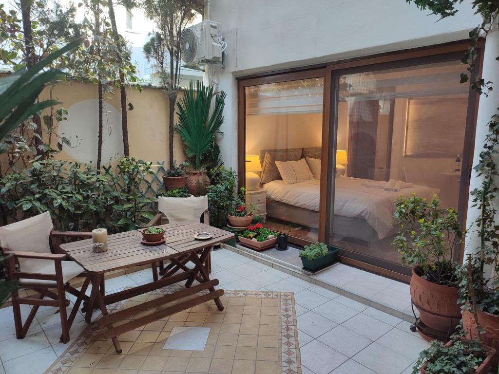 a patio with a bed and a table and some plants at Studio Apollonia in Alexandroupoli