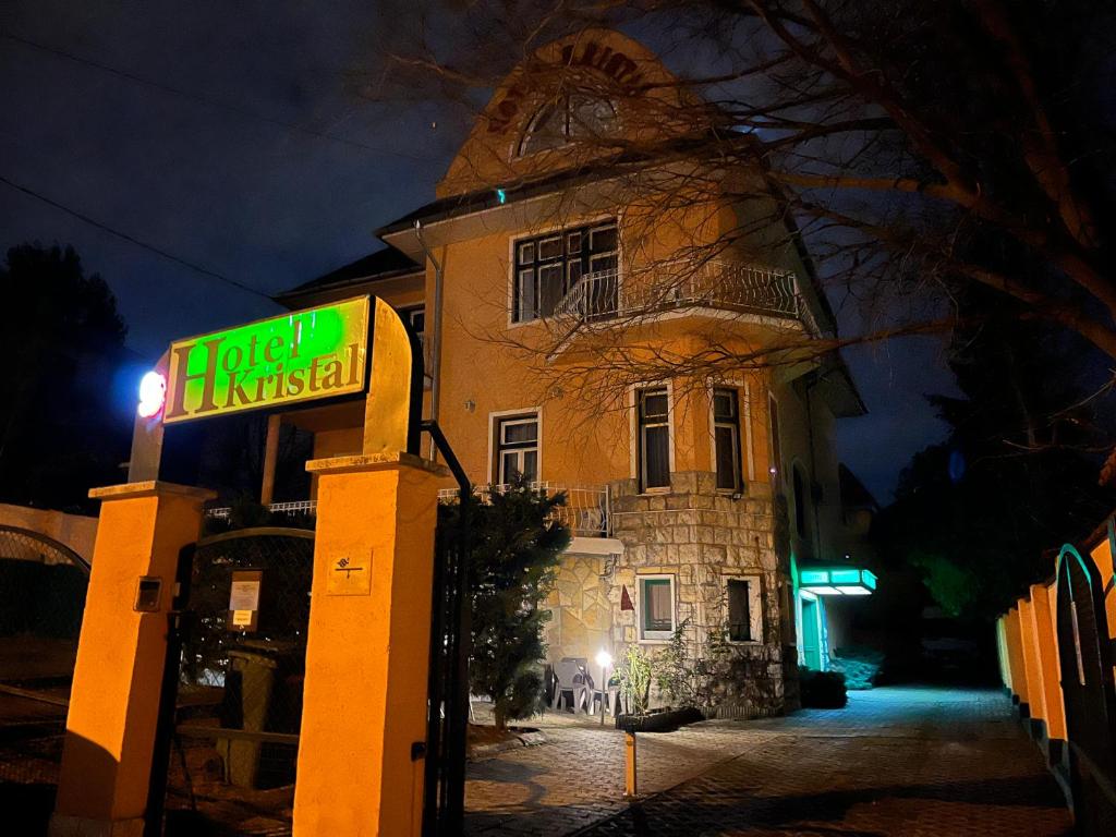 um sinal em frente a um edifício à noite em Hotel Kristal em Budapeste