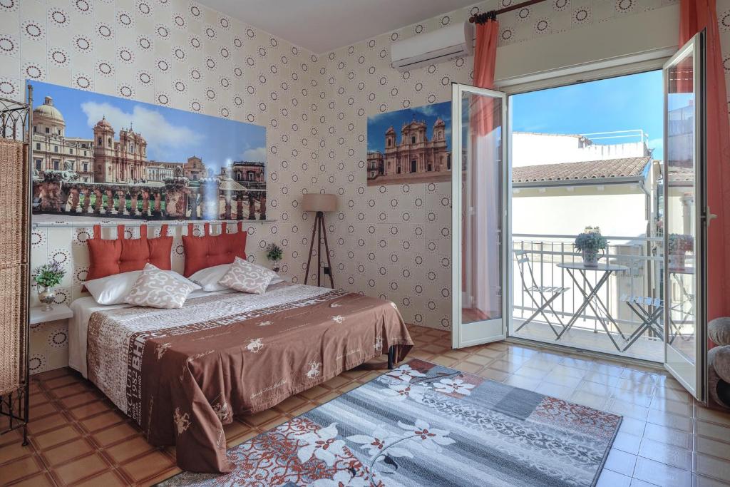 sypialnia z łóżkiem i dużym oknem w obiekcie Casa Caterina w mieście Noto